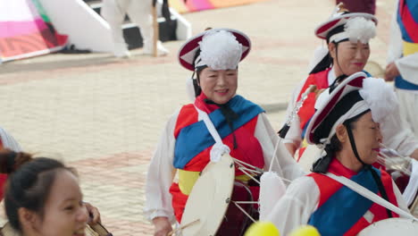 Pungmul-or-Nongak---Senior-Woman-in-Korean-Traditional-Costumes-Walk-And-Hit-Drums-at-Geumsan-Insam-Ginseng-Festival-in-Geumsan-gun,-South-Korea