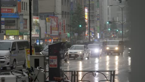 City-Centre-Crosswalk-and-Commuters-during-heavy-Rain,-Kabukicho,-Shinjuku,-Tokyo,-Japan