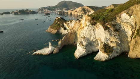 Wide-drone-panning-shot-of-the-tuff-and-kaolin-rock-formation-at-the-secret-Isola-di-Ponza-on-a-sunny-day