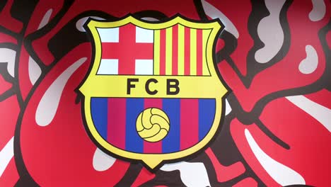 Barcelona-football-team-insignia-with-The-Rolling-Stones-band-theme-background-seen-at-its-football-stadium-facility,-Spotify-Camp-Nou,-inside-its-official-merchandise-store-in-Barcelona,-Spain