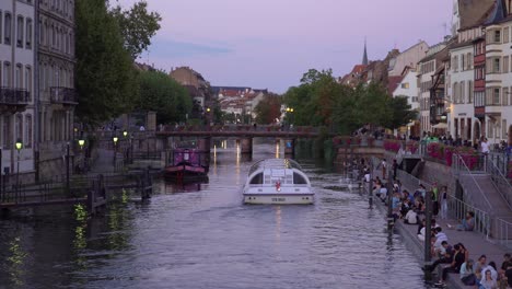 Ferry-Passes-Ill-River-in-Strasbourg-with-Youth-Enjoying-Lovely-Evening