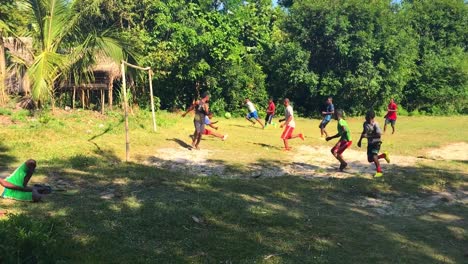 Eine-Gruppe-Glücklicher-Afrikanischer-Jungen-Spielt-An-Sonnigen-Tagen-Fußball-Auf-Dem-Staubigen-Spielplatz-Unter-Den-Bäumen