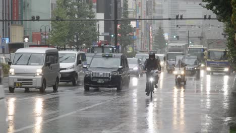 City-Centre-Road-Traffic-during-heavy-Rain,-Kabukicho,-Shinjuku,-Tokyo,-Japan