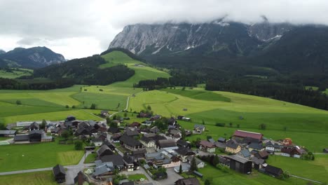 Serenidad-Alpina:-Toma-Aérea-De-4.000-Drones-De-Un-Camino-Brumoso-Desde-Graz-A-Hallstatt,-Los-Autos-Recorren-El-Campo-Austriaco-Con-Campos-Verdes-Perfectamente-Cortados-Y-Un-Impresionante-Panorama-De-Los-Alpes