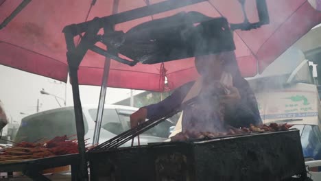 Asian-Street-Food-Hawker-Vendor-Cooking-Meat-On-A-Portable-Charcoal-Barbeque-Grill