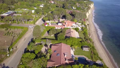 4K-Drone-Shot-of-Mansions-in-Malibu,-California-Overlooking-the-Pacific-Ocean-with-Cliffs-on-a-beautiful,-warm,-sunny-day