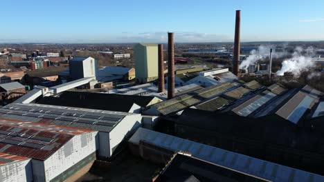Pilkington-glass-factory-warehouse-buildings-aerial-view-dolly-left-across-industrial-town-manufacturing-facility