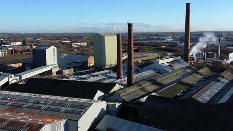 Pilkington-glass-factory-warehouse-buildings-aerial-view-industrial-town-manufacturing-facility,-zooming-in-shot