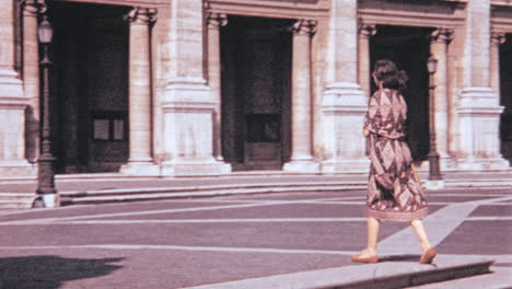 Una-Mujer-Camina-En-Un-Día-Soleado-Frente-Al-Palacio-Senatorio-De-Roma-En-Los-Años-1960