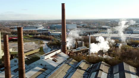 Pilkington-glass-factory-warehouse-buildings-aerial-view-circling-above-industrial-chimney-rooftop