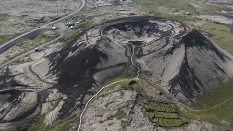 Drone-video-tilting-up-revealing-the-Grabrok-crater-with-a-small-hiking-path-leading-to-the-rim-of-this-dormant-volcano-in-Iceland