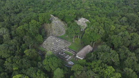 Antiguas-Ruinas-Mayas-En-Medio-De-Una-Exuberante-Selva-Verde-En-Yaxha-Cerca-De-Tikal,-Aérea
