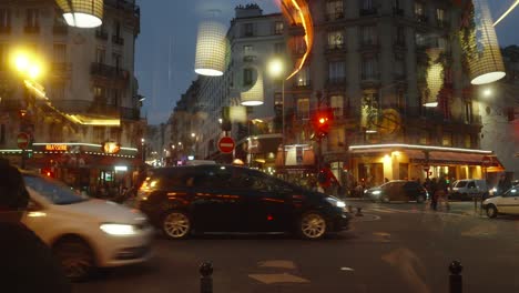 Traffic-light-in-busy-avanue-street-in-Paris,-cars-driving,-cyclist,-pedestrians-walking,-evening-shot