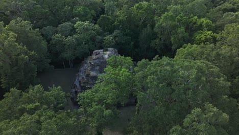 Reveal-shot-of-old-mayan-ruins-at-yaxha-in-middle-of-jungle,-aerial