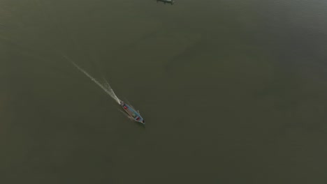 Small-fishing-boat-on-dulce-river-at-Guatemala,-aerial