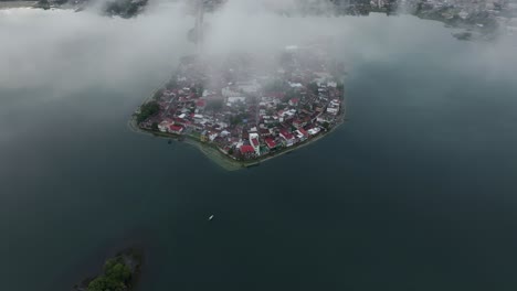 Island-of-Flores-at-Guatemala-with-low-clouds-in-the-morning,-aerial