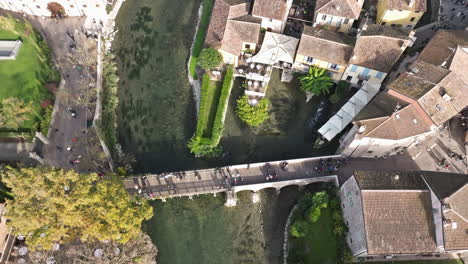 Aerial-Drone-View-Of-San-Marco-Bridge-With-Tourists-Crossing-In-Borghetto,-Valeggio-sul-Mincio,-Veneto,-Italy,-Europe