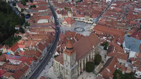 Backward-drone-of-black-church-reveal-Brasov-cityscape-in-Romania