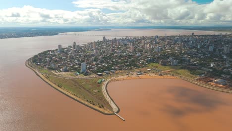 Bird's-eye-view-of-the-city-of-Posadas,-gracefully-nestled-along-the-curves-of-the-mighty-Paraná-river