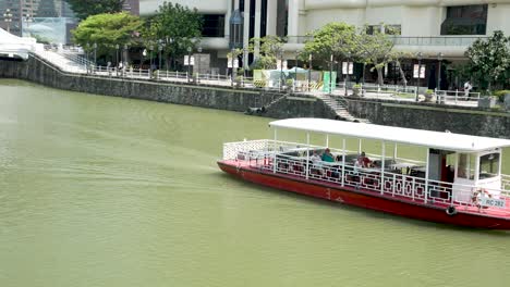Una-Toma-Estática-De-Un-Grupo-De-Turistas-Disfrutando-De-Un-Crucero-Turístico-En-Barco-Por-El-Río-Singapur-En-Un-Hermoso-Día,-Singapur.