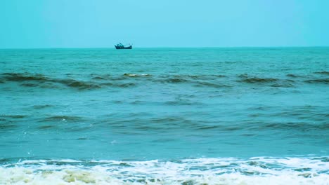Waves-in-the-sea-with-a-fishing-boat-in-the-background-at-indian-ocean