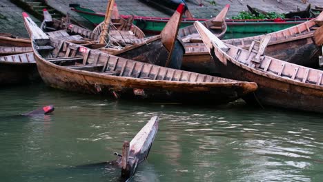 Barco-Tradicional-En-Canoa-De-Madera-Sobre-Un-Río-Contaminado-En-El-Muelle-De-Dhaka,-Bangladesh