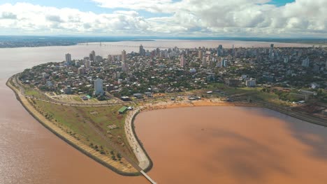 Bird's-eye-view-of-the-city-of-Posadas,-gracefully-nestled-along-the-curves-of-the-mighty-Rio-Paraná,-creating-a-picturesque-and-harmonious-urban-landscape