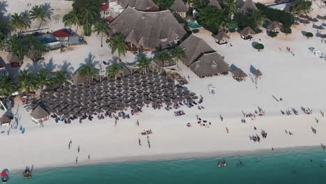 Aerial-view-of-Zanzibar-beach-where-tourists-and-locals-mix-together-of-colors-and-joy,-concept-of-summer-vacation,-aerial-view-of-Kendwa-beach,-Tanzania