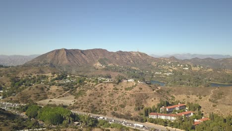 Vista-Aérea-Lenta-De-Colinas-Y-Desierto-Con-La-Ciudad-Al-Fondo-Los-Angeles