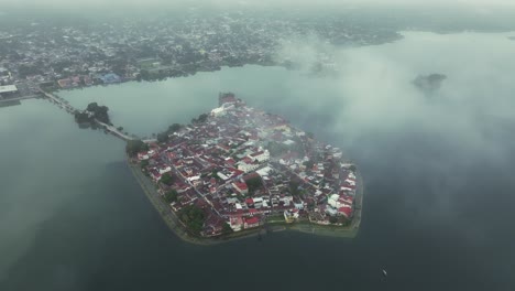Isla-El-Petén-Flores-En-Guatemala-Con-Nubes-Bajas-Amanecer,-Aéreo