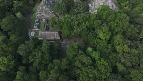 Reveal-shot-of-The-Maya-Ruins-Of-Yaxha-during-cloudy-day,-aerial