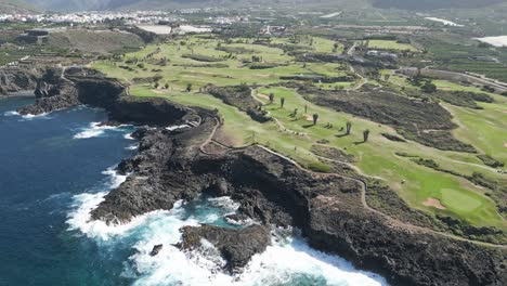 Epic-cliffside-golf-course-looks-over-beautiful-blue-ocean-in-Tenerife-Spain,-aerial-parallax