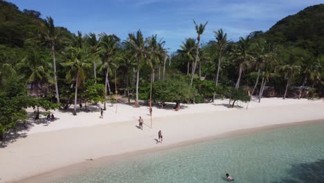 Vacationer-people-playing-volleyball-on-sandy-tropical-coco-beach-of-Bulalacao-island-on-sunny-day