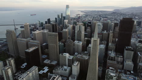 Aerial-view-orbiting-the-cityscape-of-downtown-San-Francisco,-sunrise-in-USA