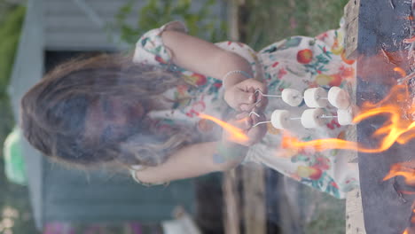 Junges-Mädchen-Röstet-Marshmallows-Auf-Metallstäben-über-Dem-Feuer
