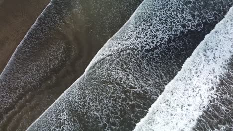 Beautiful-drone-shot-flying-over-the-black-sand-beach-in-Costa-Rica