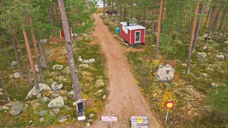 Red-Wooden-Houses-In-The-Forest-Near-The-Lake-In-Sweden---Aerial-Shot