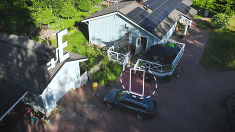 Man-plugging-in,-charging-a-EV-car-at-a-solar-powered-house---Motion-graphics
