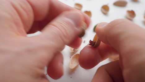 Man-peeling-pistachios-with-his-hands.-Close-up