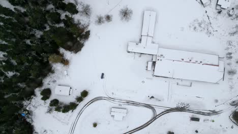 Drone-shot,-top-shot-spinning-and-rising-over-snow-covered-place
