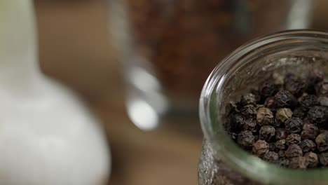 Closeup-view-of-whole-black-pepper-spice-in-jar,-ingredient-for-chimichurri