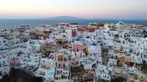 Drone-shot-of-Oia-famous-cliffside-white-houses-in-Santorini,-Greece