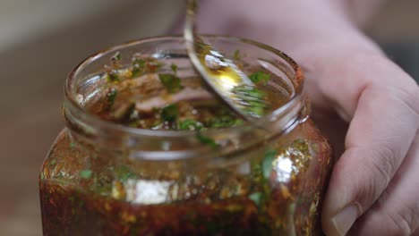 Stirring-chimichurri-sauce-in-a-jar