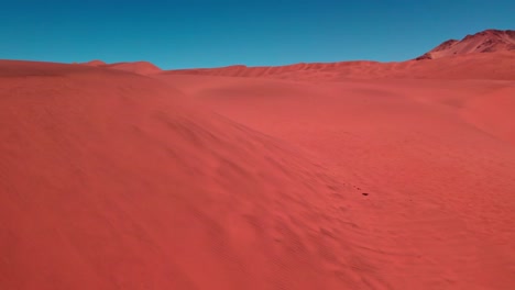Aerial-view-of-red-desert-dunes,-sunny-day-in-Atacama,-Chile