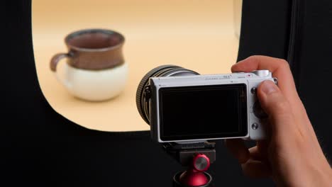 Man-taking-pictures-of-coffee-cup-in-a-light-box
