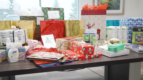 Long-4K-Row-of-Christmas-Holiday-Festive-Bed-Paper-Eve-Vacation-Presents-Wrapped-and-Sitting-in-a-Row-on-a-Meeting-Room-Table-in-a-Corporate-Office-Building-for-Secret-Santa