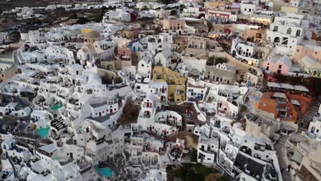 Drone-shot-of-Oia-famous-cliffside-white-houses-in-Santorini,-Greece