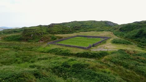 A-low-flying-drone-shot-of-an-old-and-historic-cemetery-on-a-small-and-isolated-peninsula-in-Ireland