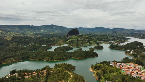 Panoramic-drone-shot-circling-the-Piedra-del-Peñol-monolith,-in-cloudy-Guatape,-Colombia