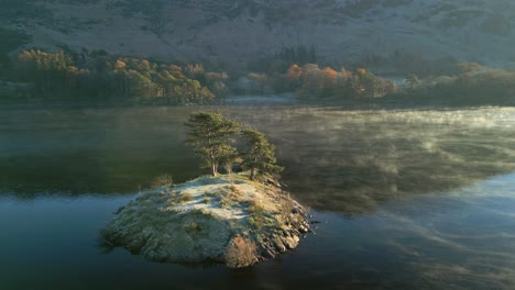 Insel-Auf-Einem-Sehr-Ruhigen-See,-Während-Bei-Sonnenaufgang-Im-Herbst-Sanfter-Nebel-über-Die-Oberfläche-Rollt